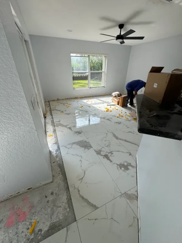 White gray-veined floor extending across a bright room beneath a ceiling fan